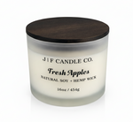 J | F Candle Co Fresh Apples 16oz soy candle in frosted glass jar with darkened label, wooden lid on top, clean white background with soft reflection