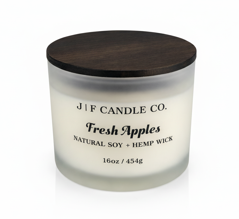 J | F Candle Co Fresh Apples 16oz soy candle in frosted glass jar with darkened label, wooden lid on top, clean white background with soft reflection