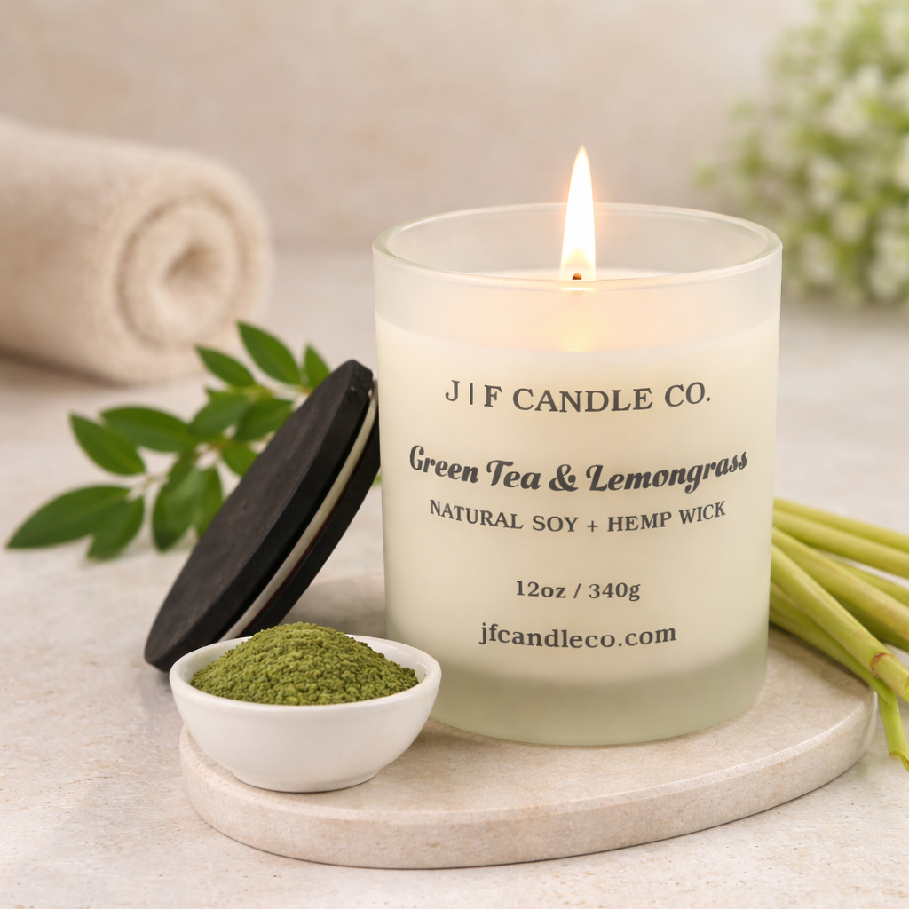 Green Tea & Lemongrass luxury soy candle by J | F Candle Co. in frosted glass jar with hemp wick, styled with matcha powder and fresh lemongrass.