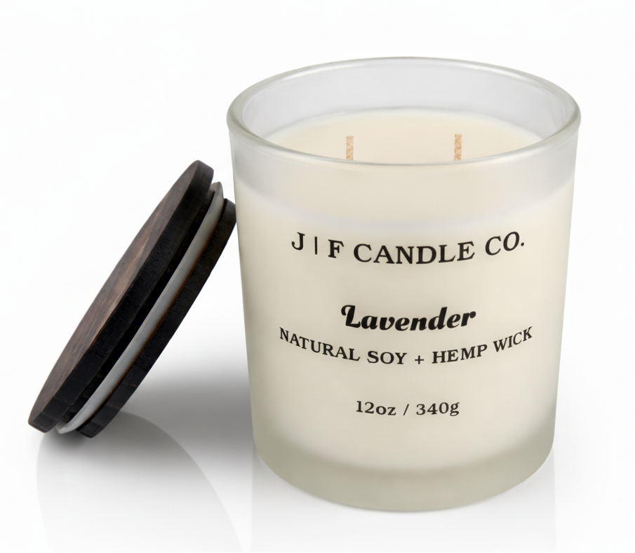 Lavender soy candle in frosted glass jar with wooden lid beside candle, natural soy wax with hemp wick by J | F Candle Co, 12oz luxury candle with soft reflection