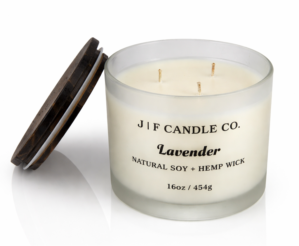 Lavender soy candle with three wicks in frosted glass jar with wooden lid beside candle, clean-burning natural soy wax with hemp wicks by J | F Candle Co, 16oz luxury candle with soft reflection