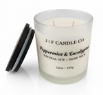 J | F Candle Co Peppermint & Eucalyptus 12oz soy candle in frosted glass jar with wooden lid beside candle, clean white background with soft reflection, luxury spa-inspired scent