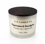 J | F Candle Co Peppermint & Eucalyptus 16oz soy candle in frosted glass jar with wooden lid, clean white background with soft reflection, luxury spa-inspired scent