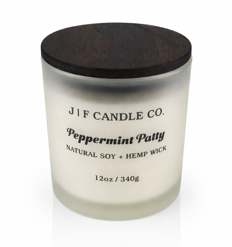 J | F Candle Co Peppermint Patty 12oz soy candle in frosted glass jar with wooden lid, clean white background with soft reflection, rich mint chocolate inspired scent