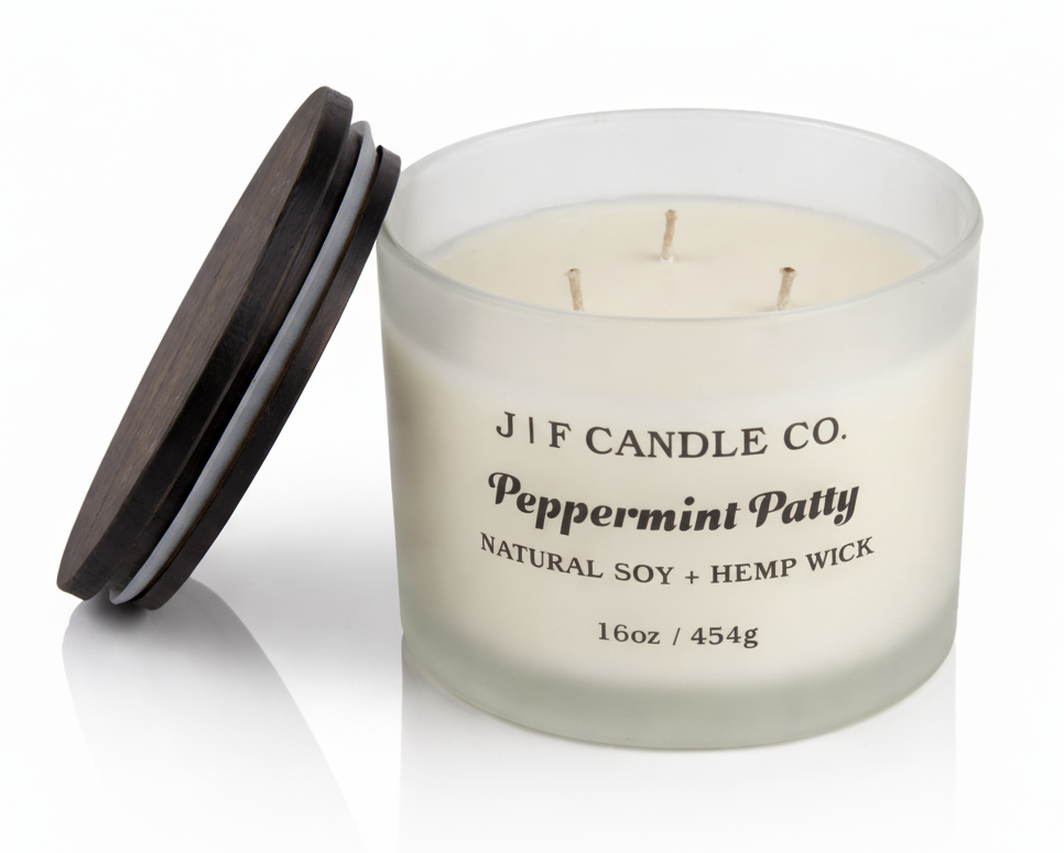 J | F Candle Co Peppermint Patty luxury soy candle 16oz three wick frosted glass jar with wooden lid and soft reflection on white background