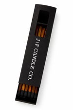 J | F Candle Co premium black matchbox with wooden matches partially open viewed from above on clean white background