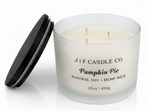J | F Candle Co Pumpkin Pie 16oz luxury soy candle with triple wicks in frosted glass jar and wooden lid beside it, clean product photo with soft reflection