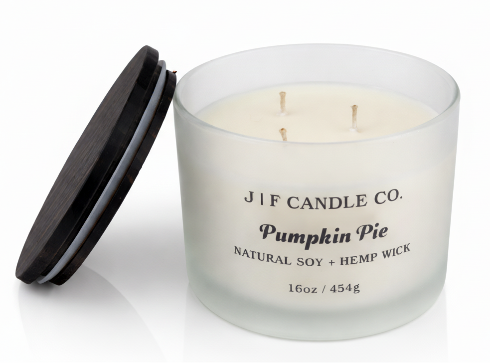 J | F Candle Co Pumpkin Pie 16oz luxury soy candle with triple wicks in frosted glass jar and wooden lid beside it, clean product photo with soft reflection