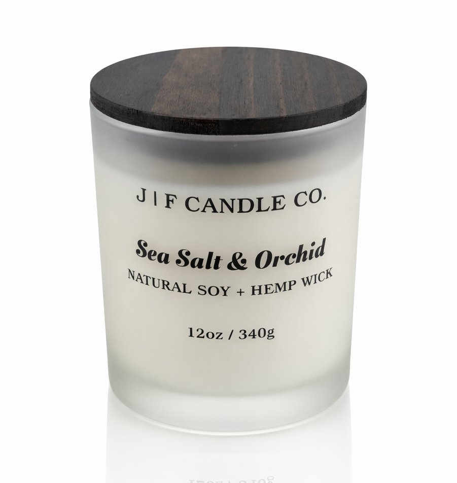 Luxury Sea Salt & Orchid soy candle by J | F Candle Co in a frosted glass jar with wooden lid, clean burn natural soy wax with soft reflection on white background