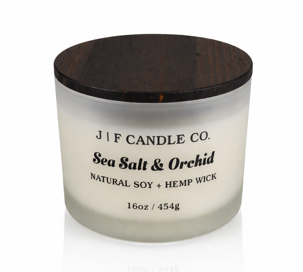 Sea Salt & Orchid 16oz soy candle by J | F Candle Co in a frosted glass jar with wooden lid, clean burning natural soy wax with soft reflection on white background