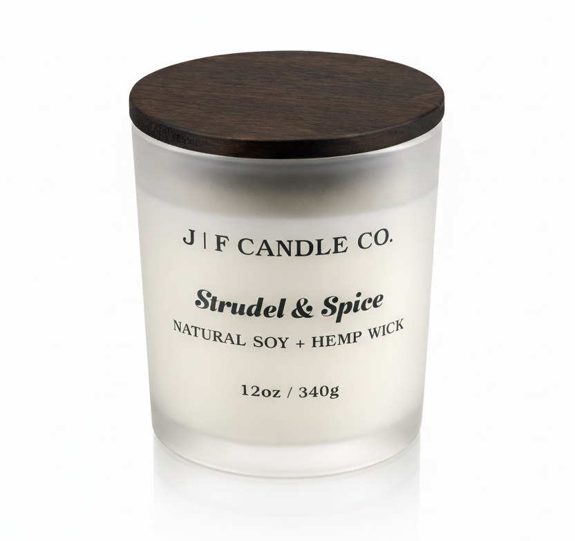 J | F Candle Co. Strudel & Spice soy candle in frosted glass jar with wooden lid, clean white background and soft reflection for luxury product display