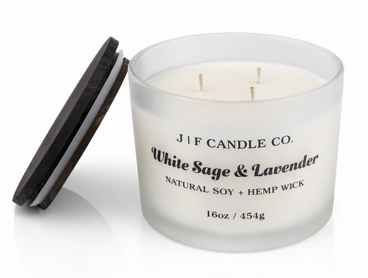 White Sage & Lavender 16 oz three-wick soy candle by J | F Candle Co. in frosted glass jar with wooden lid beside it, clean white background with soft reflection, hand-poured luxury candle